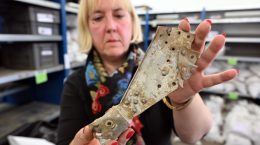 Archaeologist Tünde Kaszab-Olschewski holds in her hands parts of a British bomber that crashed in Germany in 1943. Credit: Federico Gambarini/dpa